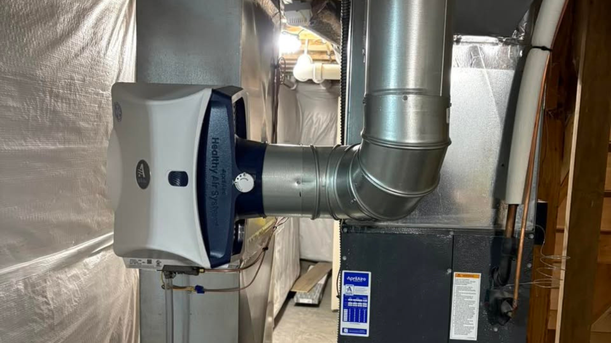 Whole-home humidifier installed on the ductwork beside a residential furnace